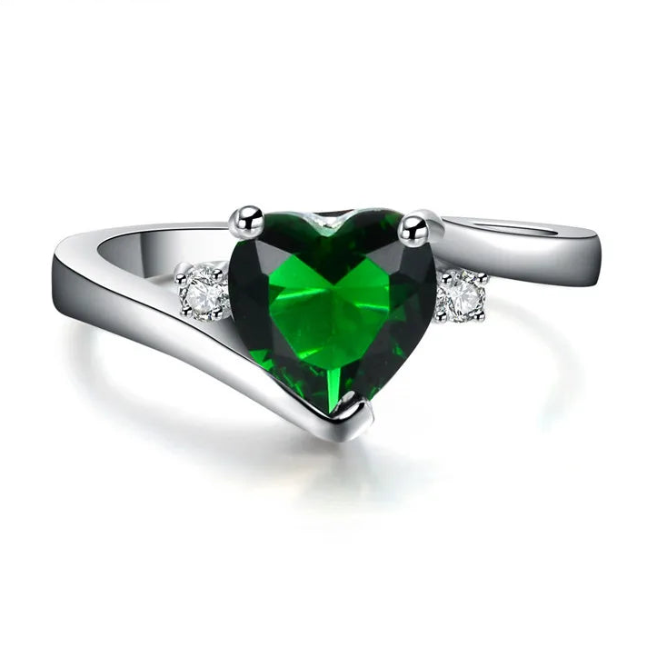 Silver ring with a heart-shaped green gemstone on a white background