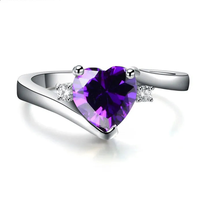 Silver ring with a heart-shaped purple gemstone on a white background