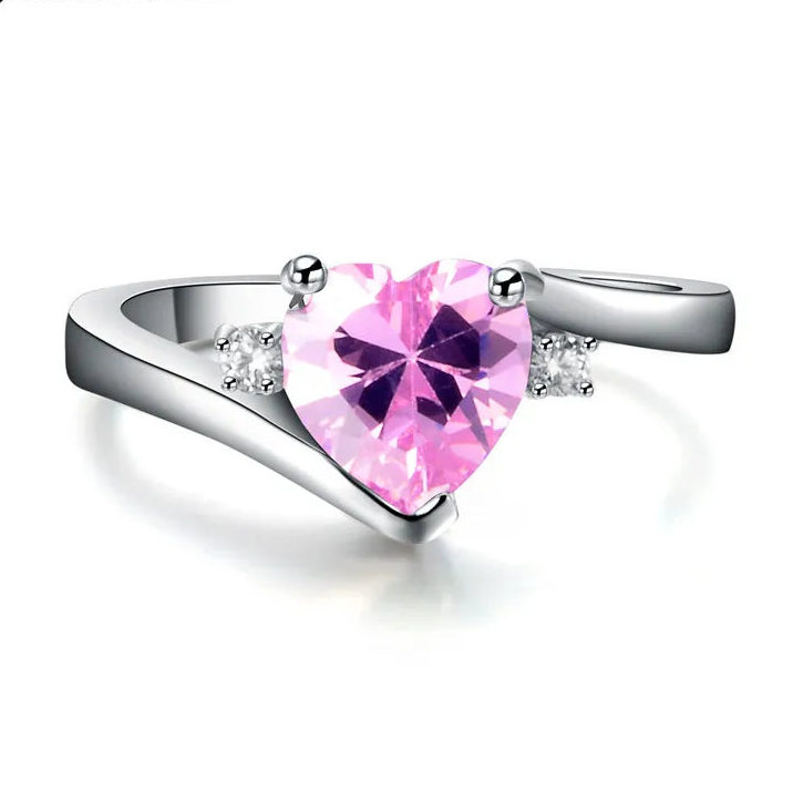 Silver ring with a heart-shaped pink gemstone on a white background, featuring the brand 'Jun Xin'.