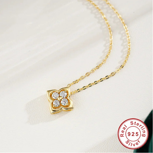 Gold necklace with a clover-shaped pendant on a white background, featuring the Coderia brand.