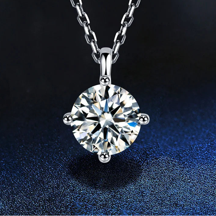 Silver necklace with a round diamond pendant on a dark background