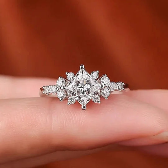 Silver ring with diamonds on a finger, brand 'CODERIA' visible