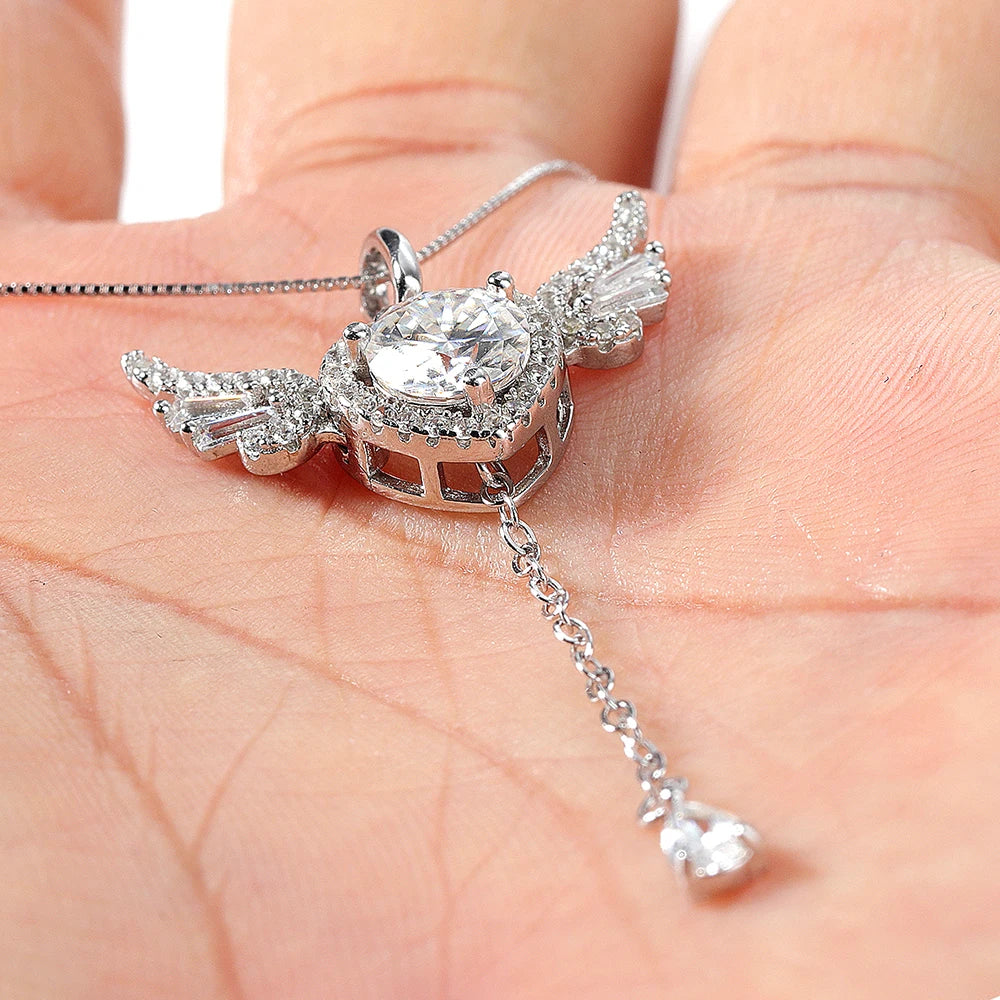 Silver necklace with a large diamond pendant held in a hand.