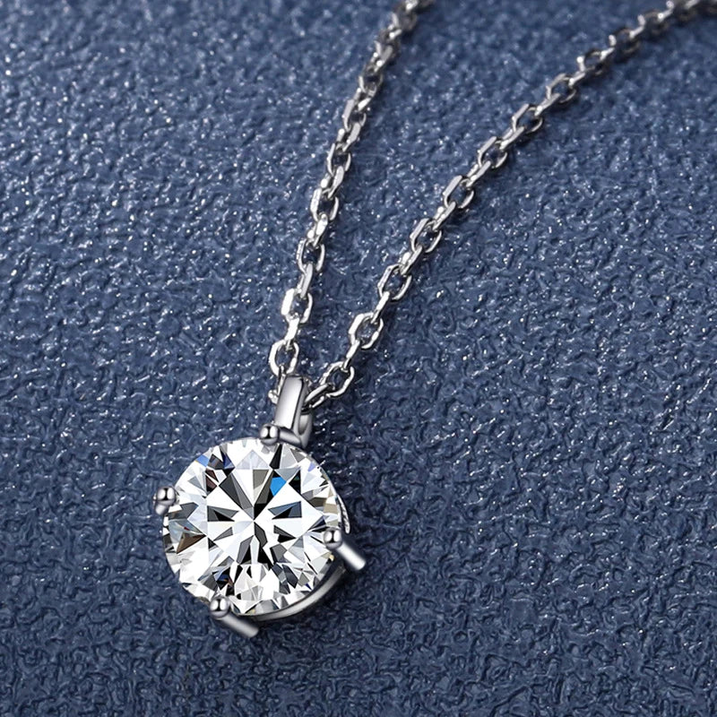 Silver necklace with a round diamond pendant on a textured blue background